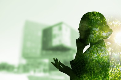 Double exposure of businesswoman and green tree in city