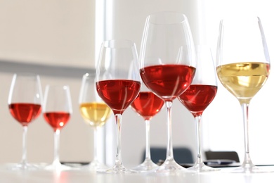 Photo of Glasses with delicious wine on table indoors