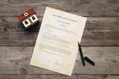 Photo of Last Will and Testament with fountain pen and house model on wooden table, top view