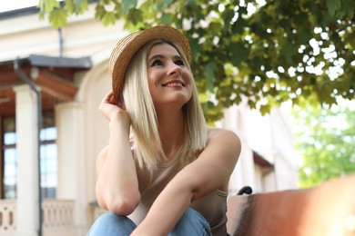 Photo of Portrait of beautiful woman in straw hat on city street