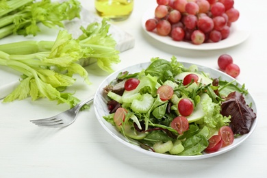 Delicious fresh celery salad on white wooden table, closeup