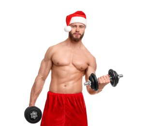 Photo of Attractive young man with muscular body in Santa hat holding dumbbells on white background
