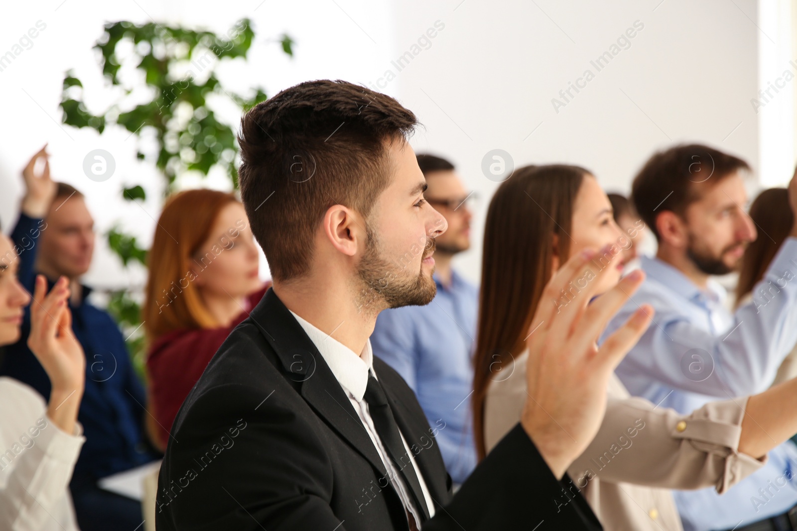 Photo of People raising hands to ask questions at business training indoors