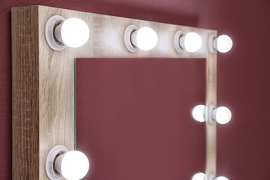 Photo of Beautiful mirror in modern makeup room, closeup