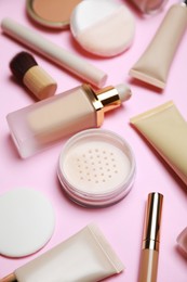 Face powder and other decorative cosmetic products on pink background