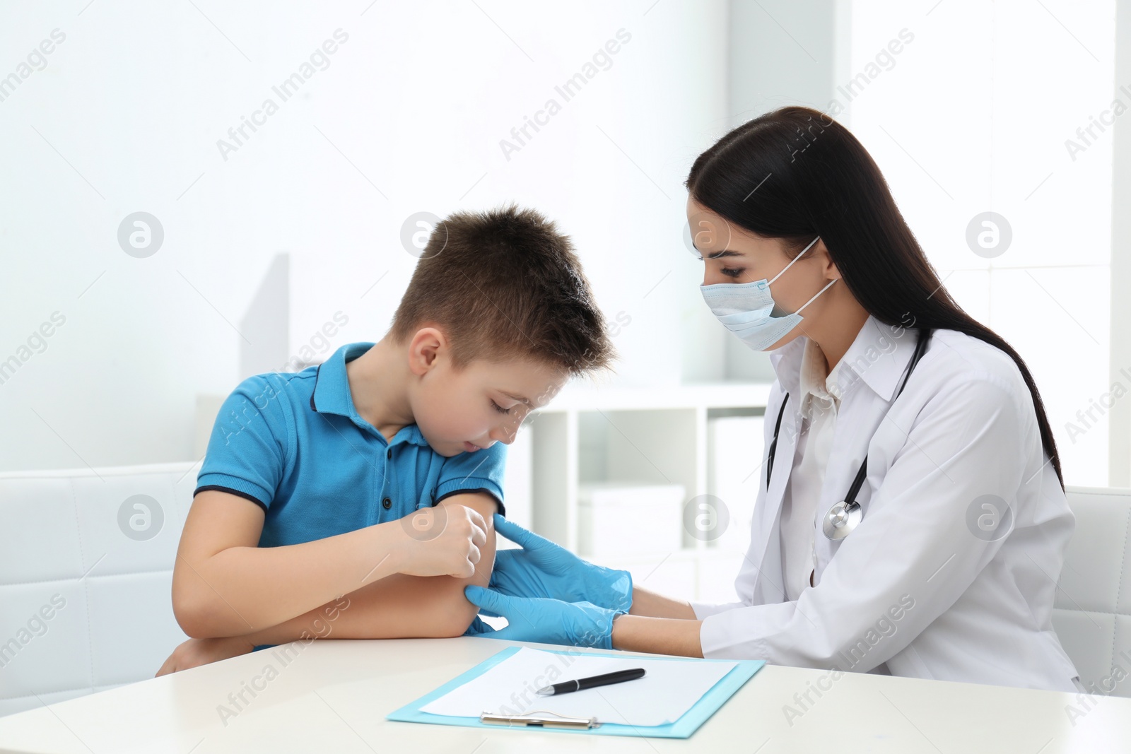 Photo of Doctor examining little patient before vaccination in clinic