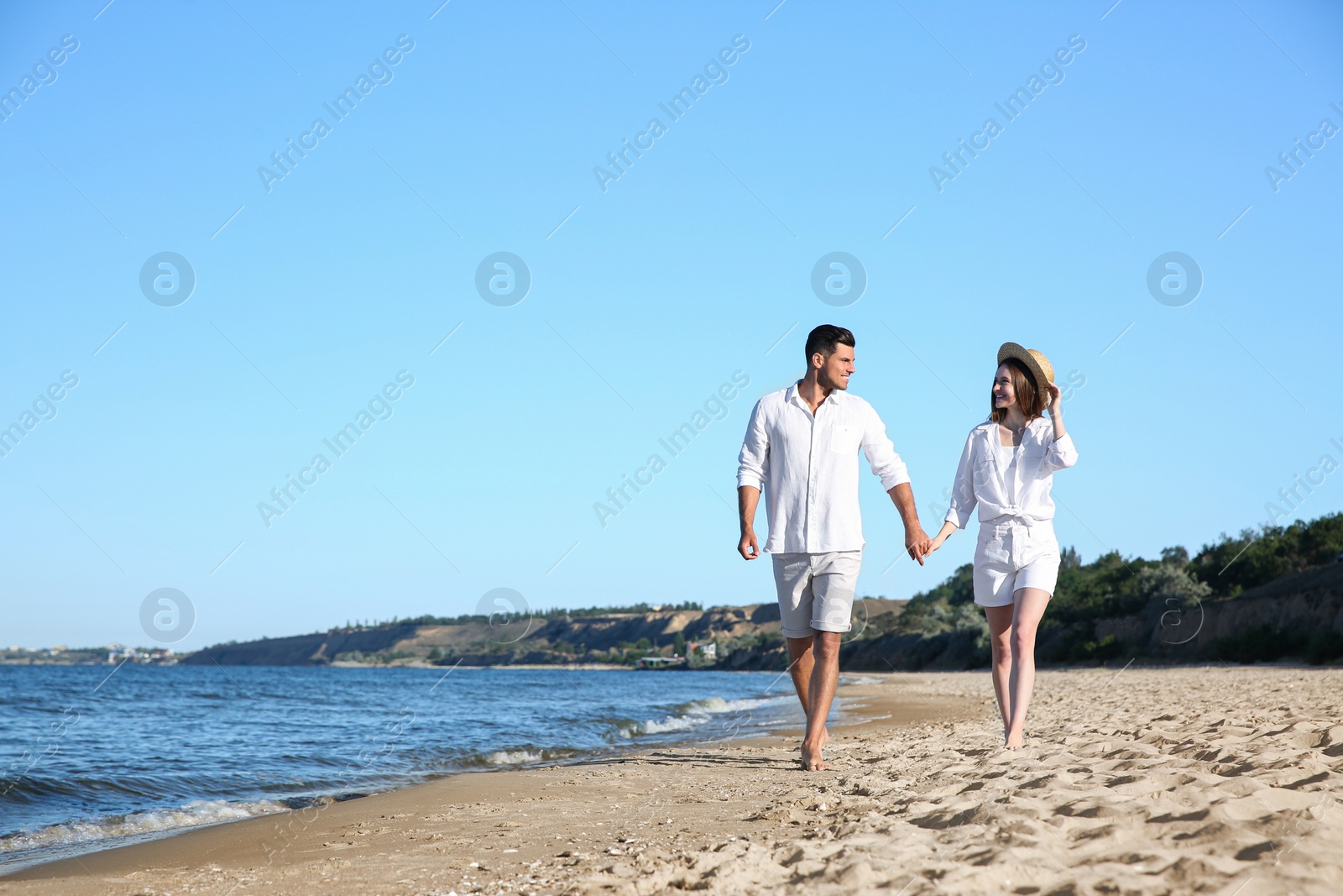 Photo of Lovely couple walking on beach. Space for text