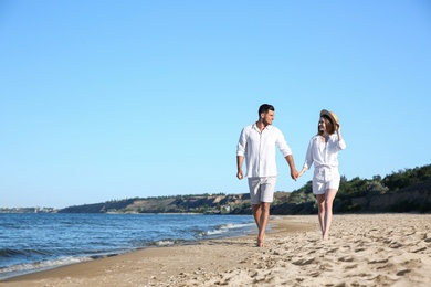 Photo of Lovely couple walking on beach. Space for text