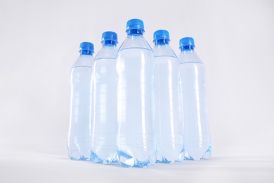 Photo of Plastic bottles with pure water on white background