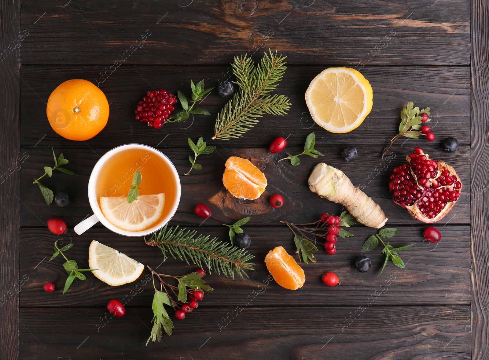 Photo of Flat lay composition with cup of delicious immunity boosting tea and ingredients on wooden table