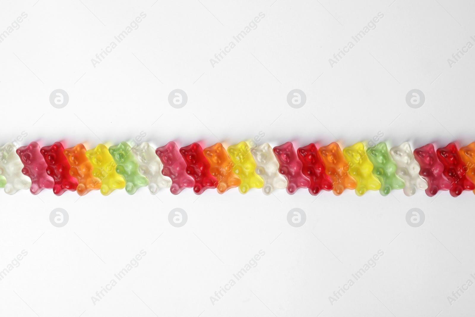 Photo of Row of delicious jelly bears on white background, top view