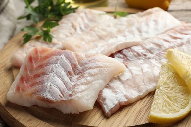 Photo of Fresh raw cod fillets on wooden table, closeup