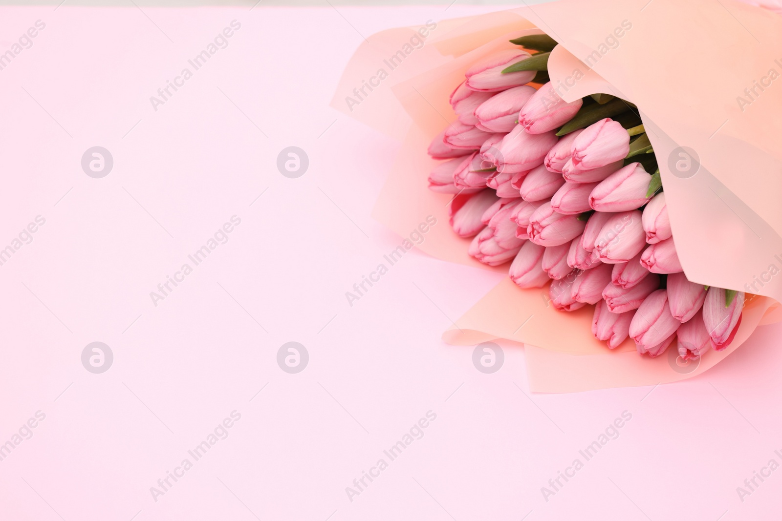 Photo of Bouquet of beautiful tulips on pink background, closeup. Space for text