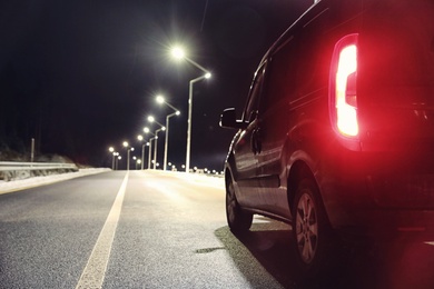 Modern car on asphalt road at night