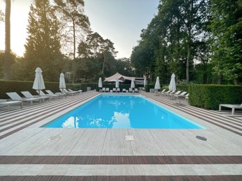 Photo of Outdoor swimming pool in luxury hotel on sunny summer day. Time for relax