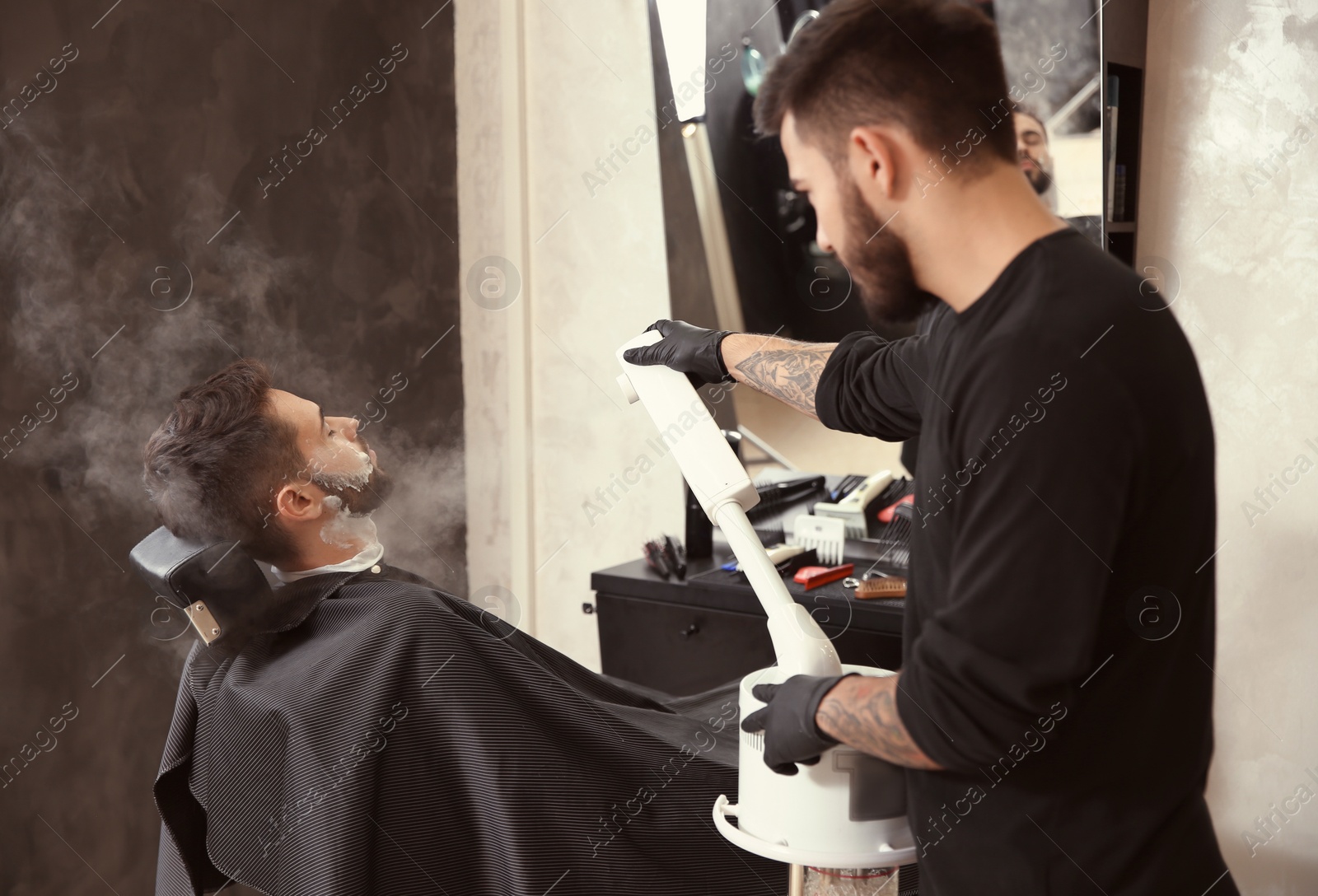 Photo of Hairdresser working with client at barbershop. Professional shaving service