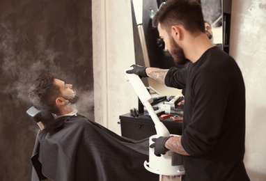 Hairdresser working with client at barbershop. Professional shaving service