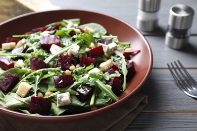 Fresh delicious beet salad on grey wooden table, closeup