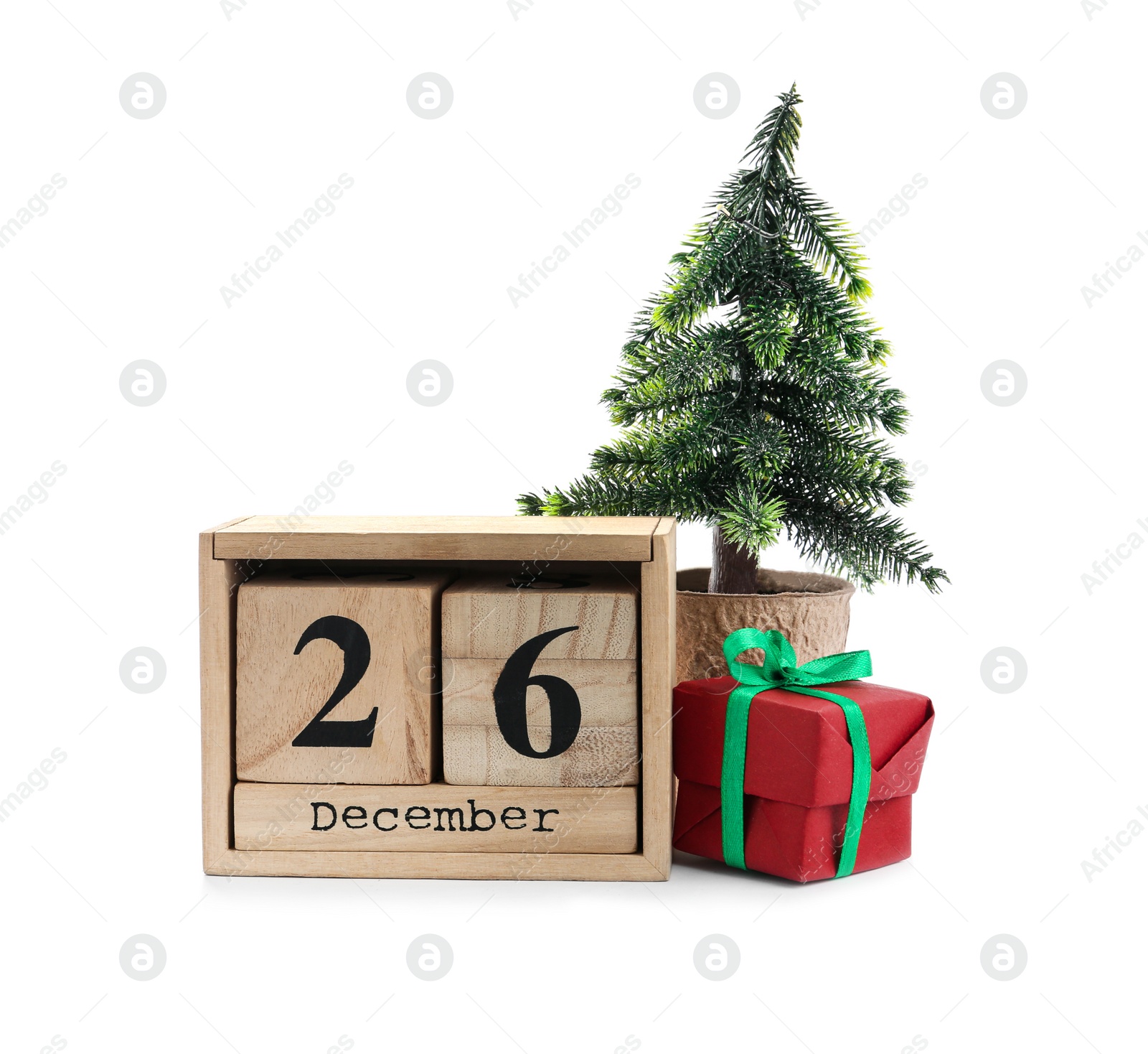 Photo of Wooden block calendar with Boxing Day date, gift and decorative Christmas tree on white background