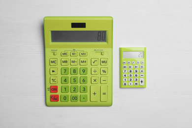 Photo of Different calculators with numbers 80 and 20 on white wooden background, flat lay. Pareto principle concept