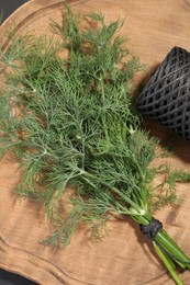 Photo of Bunch of fresh dill and spool of thread on table, flat lay