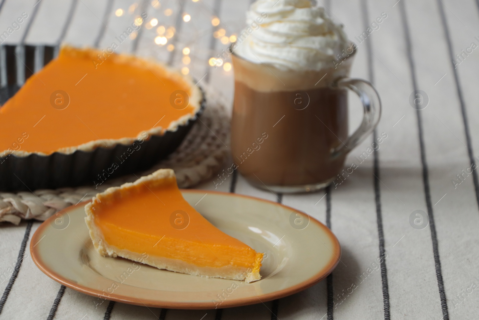 Photo of Fresh homemade pumpkin pie and cup of cocoa with whipped cream on table