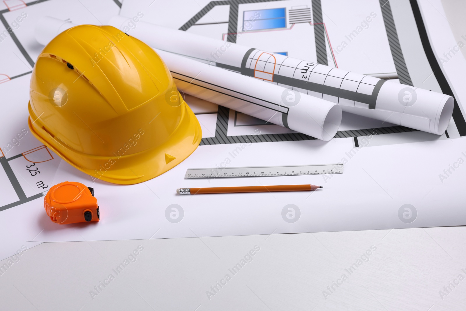 Photo of Construction drawings, safety hat, tape measure, pencil and ruler on white background