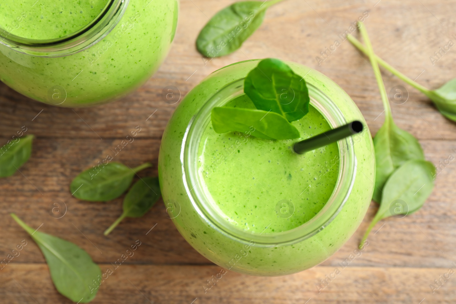 Photo of Flat lay composition with fresh green healthy spinach smoothie on wooden table