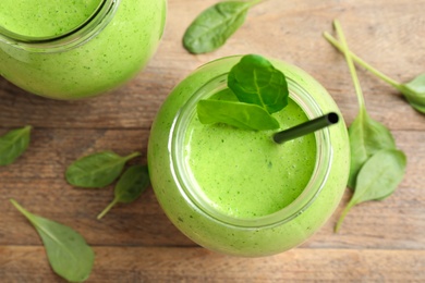 Flat lay composition with fresh green healthy spinach smoothie on wooden table