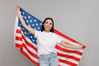 Photo of 4th of July - Independence Day of USA. Happy woman with American flag on light grey background