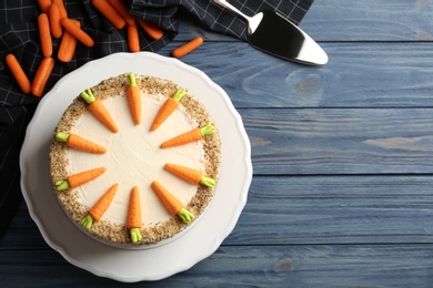 Flat lay composition with delicious carrot cake on blue wooden background, space for text