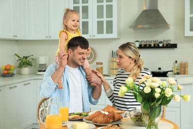 Happy family having fun during breakfast in kitchen