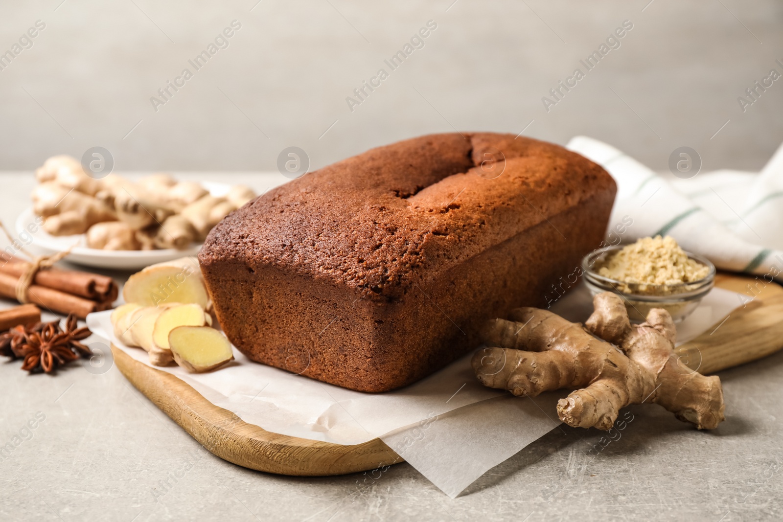 Photo of Delicious gingerbread cake and ingredients on light grey table