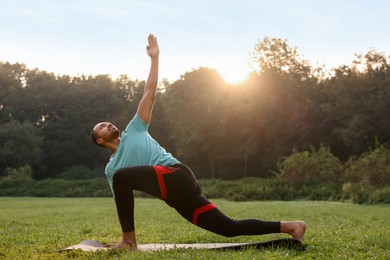 Photo of Man practicing yoga outdoors on sunny day