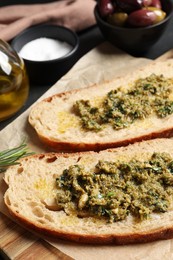 Photo of Tasty bruschettas with pesto on wooden board, closeup