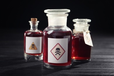 Photo of Bottles with poison on black wooden table