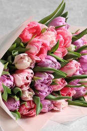 Photo of Bouquet of beautiful tulips on white table, closeup