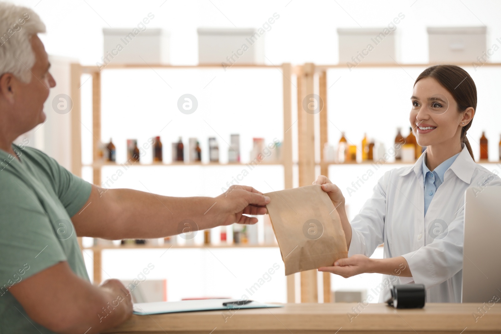 Photo of Pharmacist giving medicine to customer in drugstore