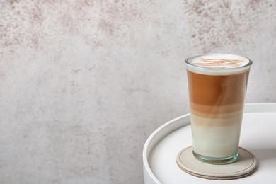 Photo of Glass of tasty caramel macchiato on table, Space for text