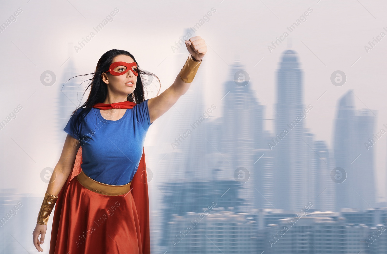Image of Confident young woman wearing superhero costume and beautiful cityscape on background
