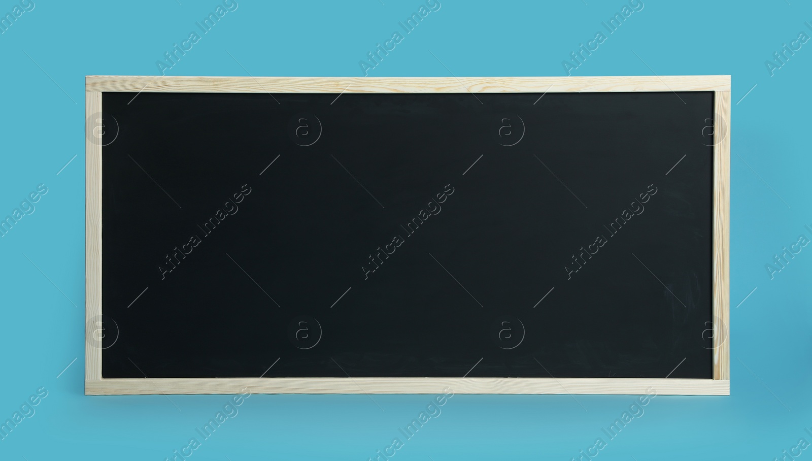 Photo of Clean black chalkboard on light blue background