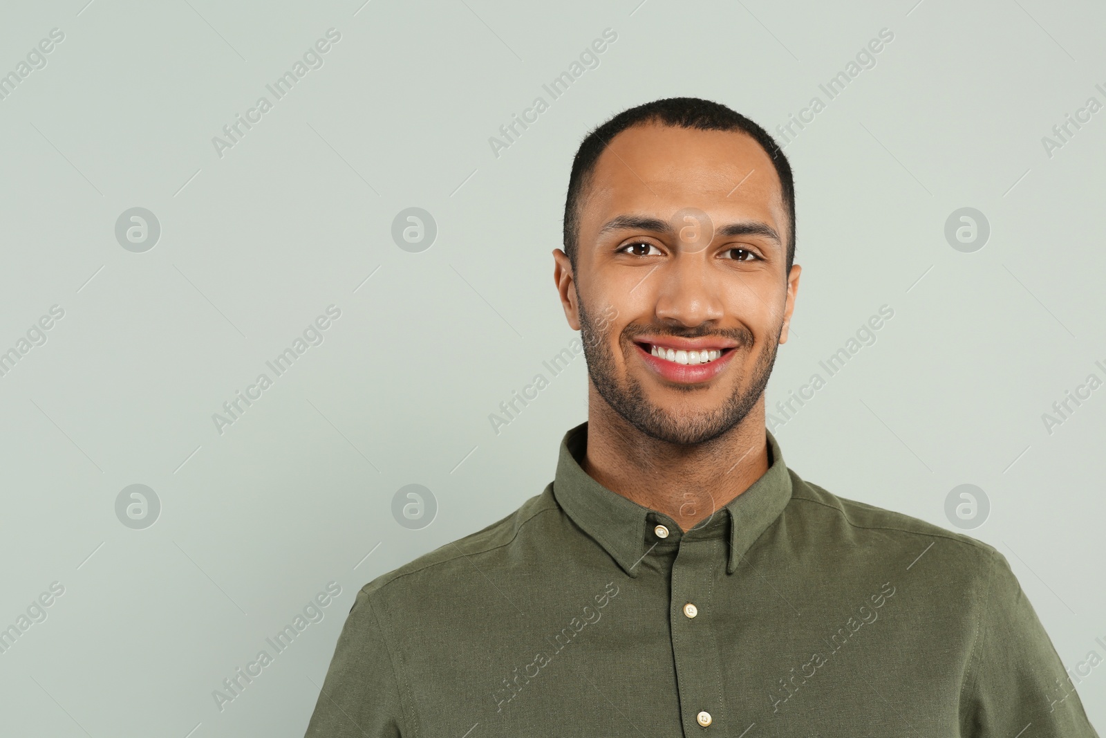 Photo of Portrait of handsome young man on gray background, space for text