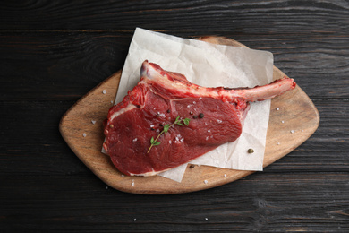 Photo of Fresh raw beef cut on wooden table, top view
