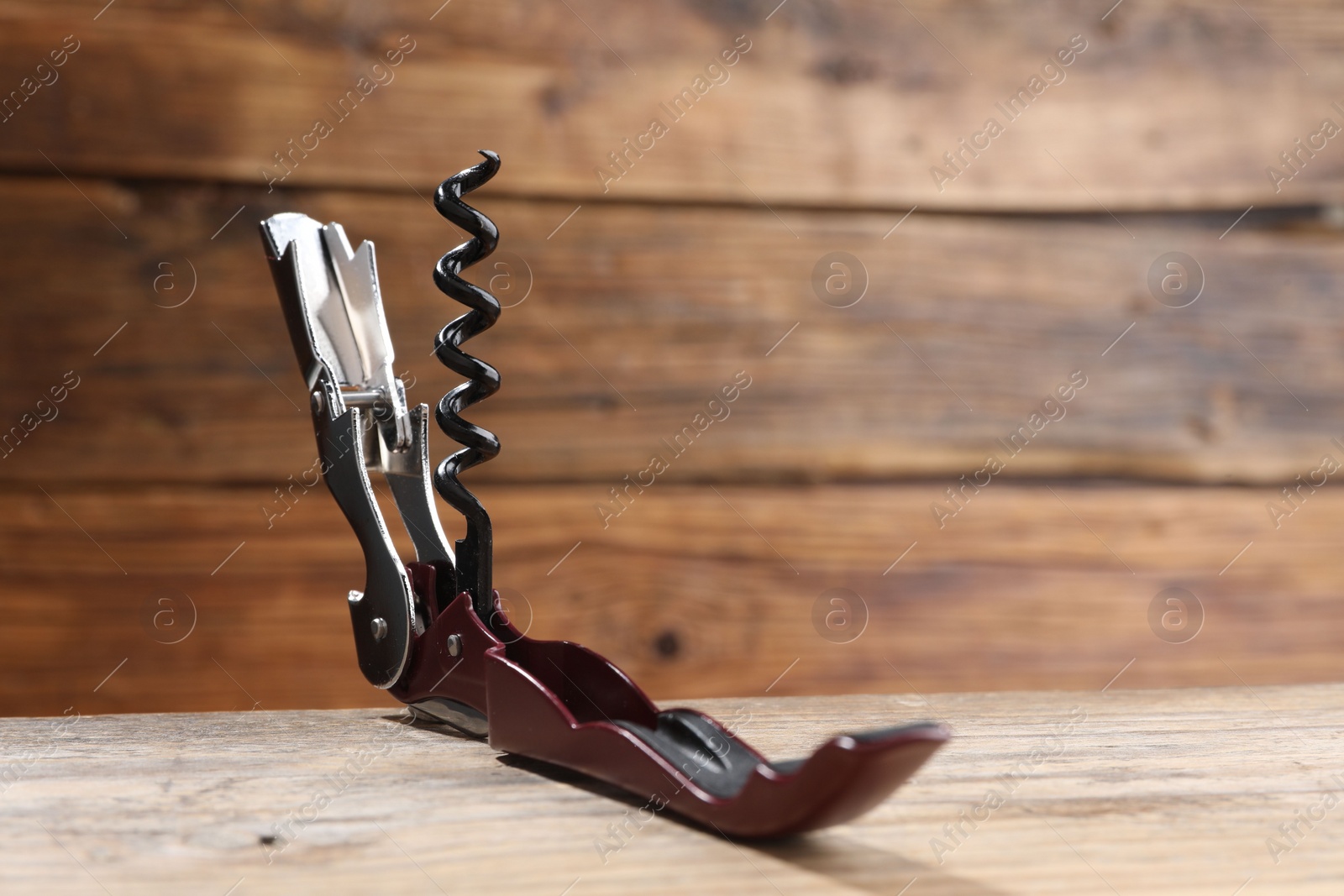Photo of One corkscrew (sommelier knife) on wooden table, closeup