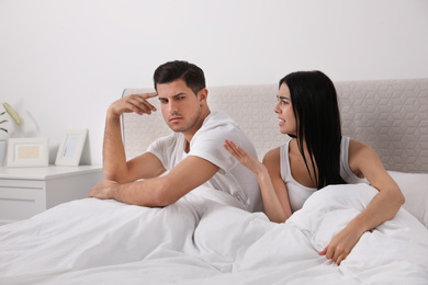 Photo of Couple with relationship problems quarreling in bedroom