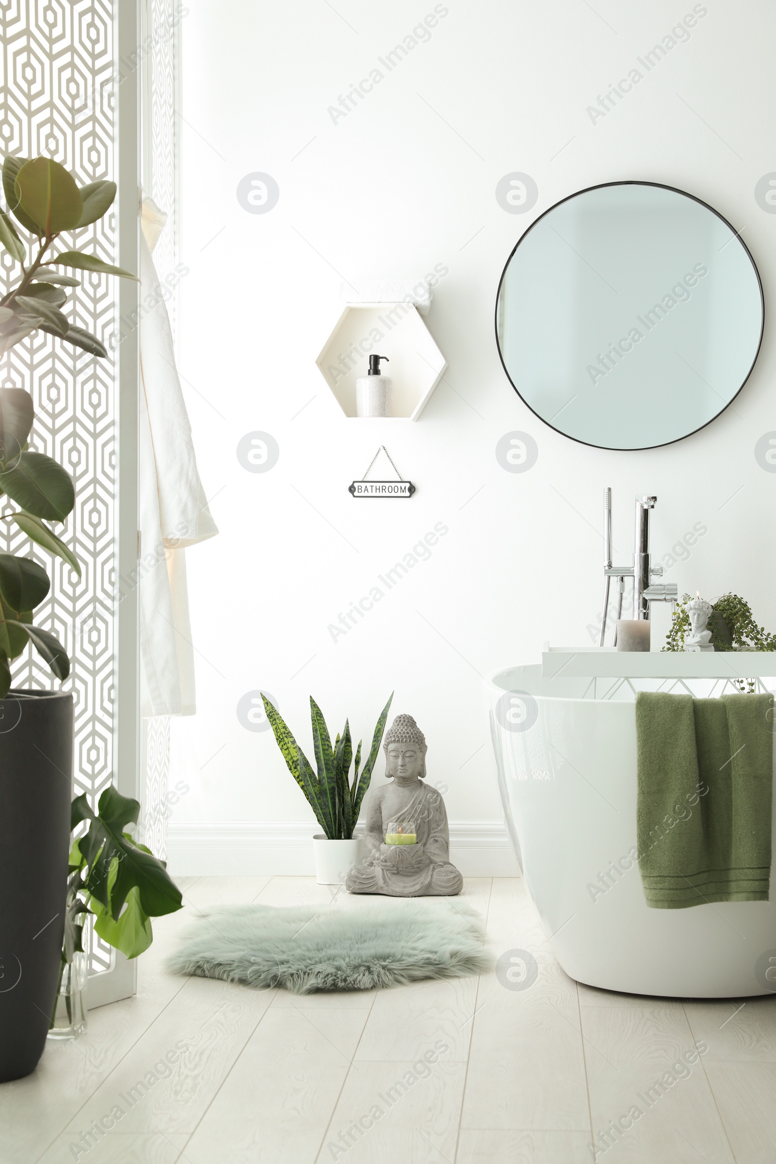 Photo of Stylish bathroom interior with modern tub, houseplants and beautiful decor. Home design