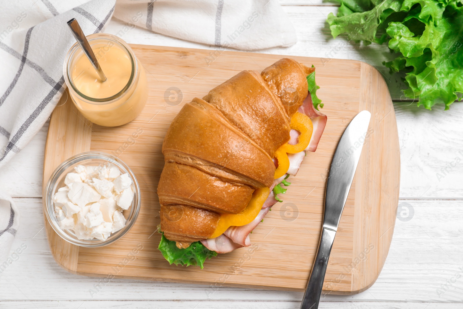 Photo of Tasty croissant sandwich with ham on white wooden table, flat lay