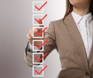 Woman pointing at check boxes with marks on virtual screen, closeup