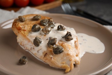 Photo of Delicious chicken fillet with capers and sauce on plate, closeup