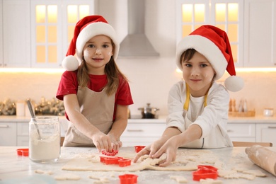 Photo of Cute little children making Christmas cookies in kitchen
